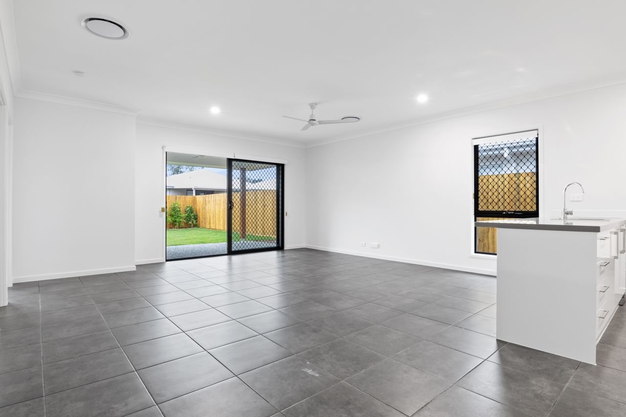 Bright and empty modern living room with sliding doors and tiled floor.